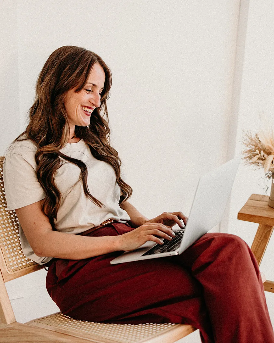 Nina Grimm arbeitet lachend am Laptop